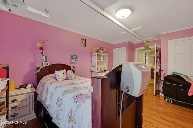 bedroom with crown molding and light hardwood / wood-style floors