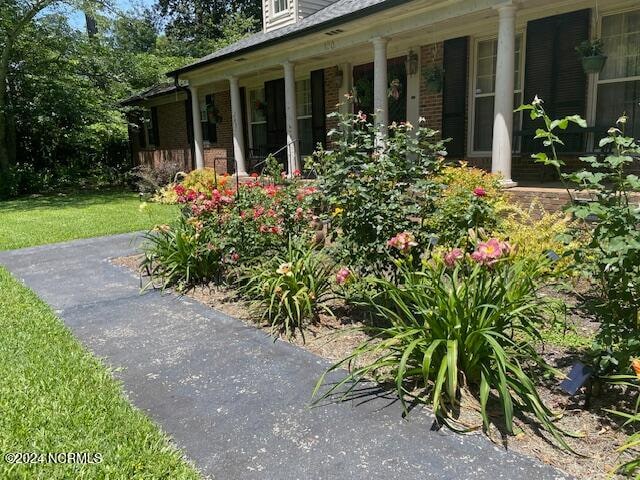 view of side of property featuring covered porch