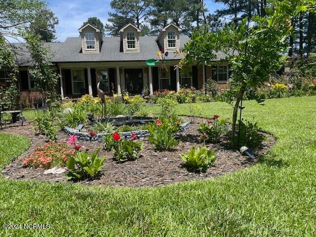 cape cod home with a front lawn