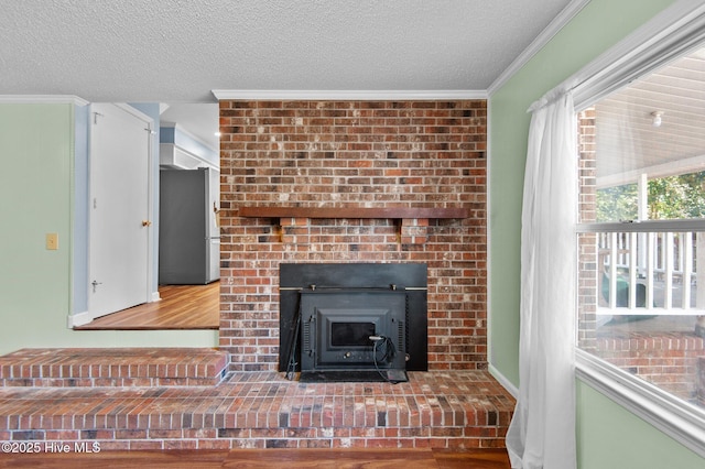 details with hardwood / wood-style floors, a textured ceiling, stainless steel refrigerator, and crown molding