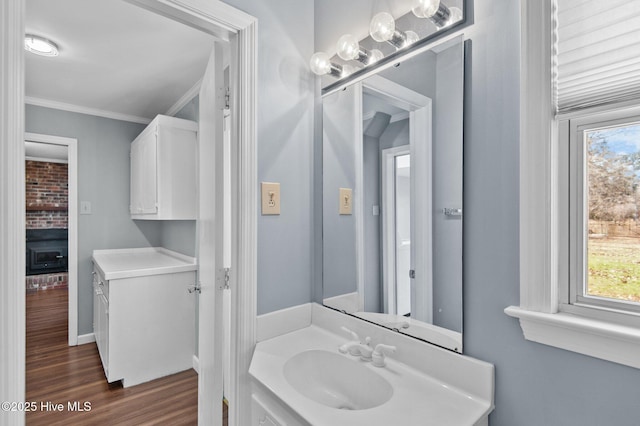 bathroom with crown molding, hardwood / wood-style floors, and vanity