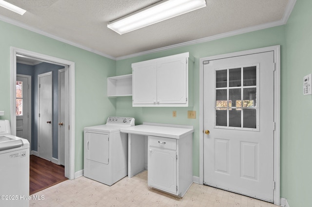 laundry area with cabinets, a textured ceiling, washer and clothes dryer, and ornamental molding