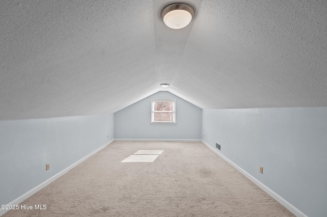 bonus room with light carpet and lofted ceiling