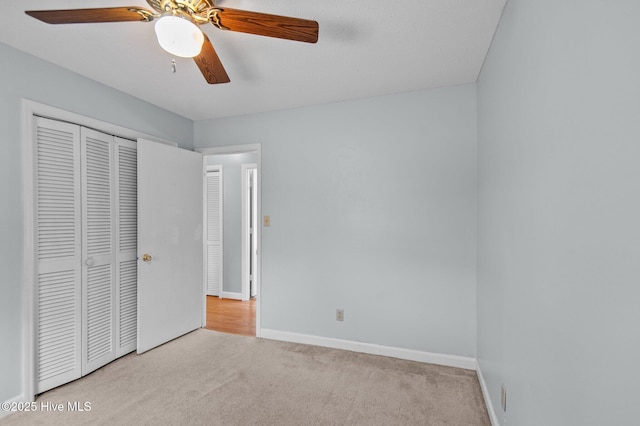 unfurnished bedroom featuring ceiling fan, light carpet, and a closet