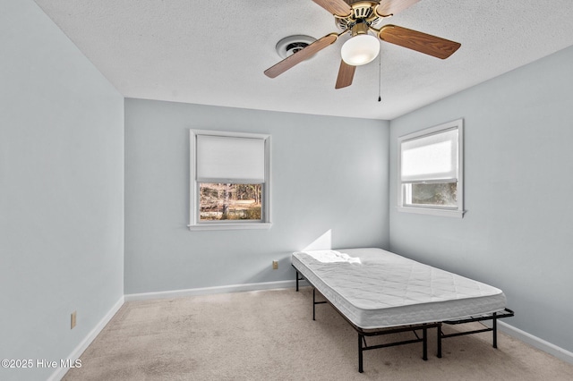 bedroom with ceiling fan and a textured ceiling