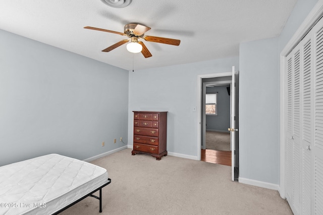 carpeted bedroom featuring ceiling fan and a closet