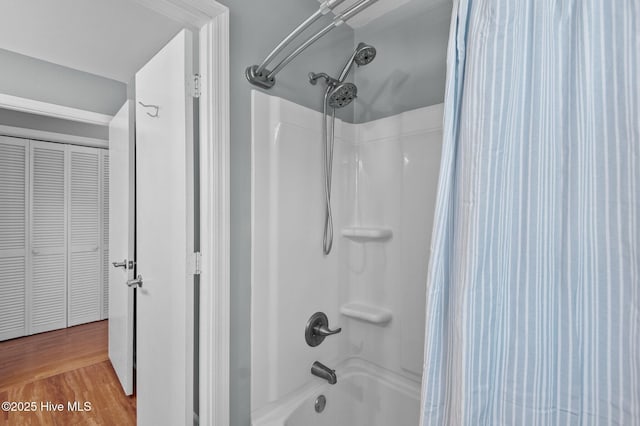 bathroom featuring wood-type flooring and shower / bathtub combination