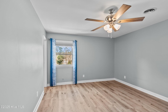 empty room with ceiling fan and light hardwood / wood-style flooring