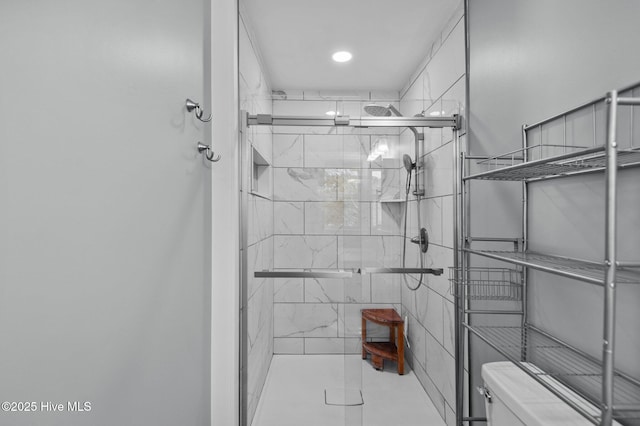 bathroom featuring tile patterned flooring, toilet, and walk in shower