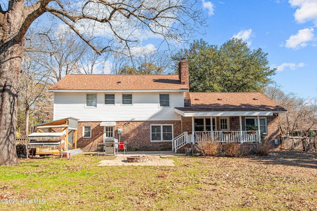 back of house with a yard, a patio, and an outdoor fire pit