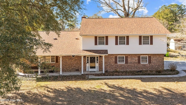 217 Randomwood Ln, River Bend, NC 28562 - view of front of house featuring brick siding, a chimney, and roof with shingles