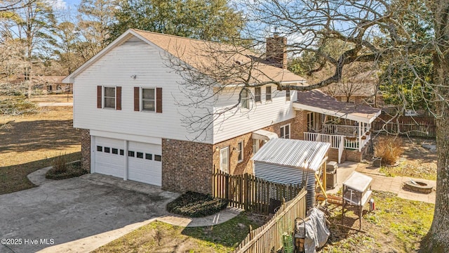 217 Randomwood Ln, River Bend, NC 28562 - view of home's exterior with brick siding, a garage, concrete driveway, and a chimney