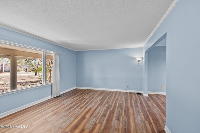 unfurnished room with wood-type flooring, a textured ceiling, and ornamental molding