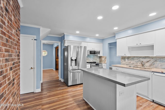 217 Randomwood Ln, River Bend, NC 28562 - kitchen featuring appliances with stainless steel finishes, a sink, crown molding, white cabinetry, and backsplash