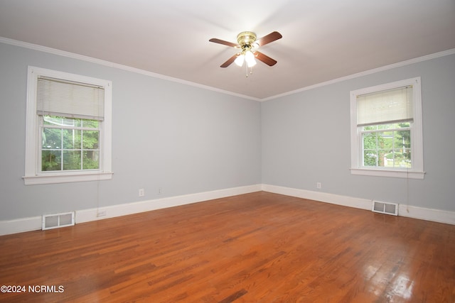 empty room with wood-type flooring, plenty of natural light, and ornamental molding