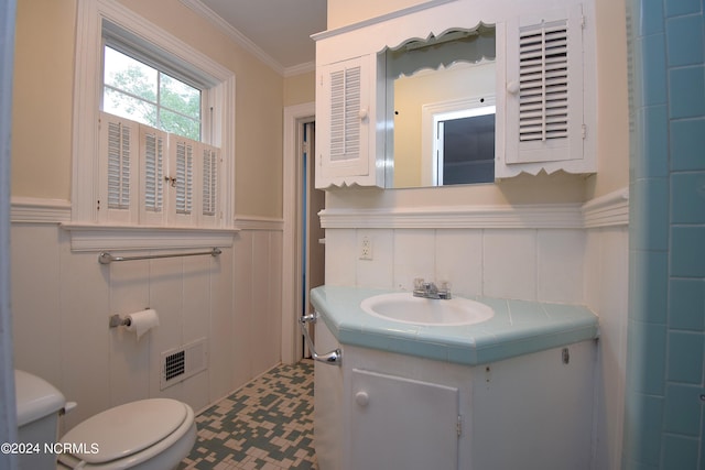 bathroom with ornamental molding, vanity, and toilet