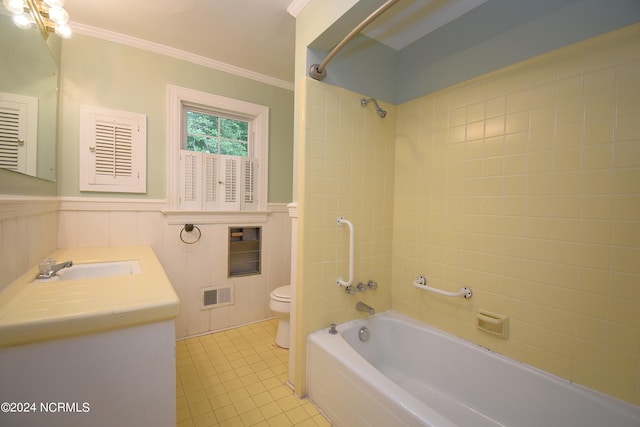 full bathroom with ornamental molding, vanity, tiled shower / bath combo, and toilet