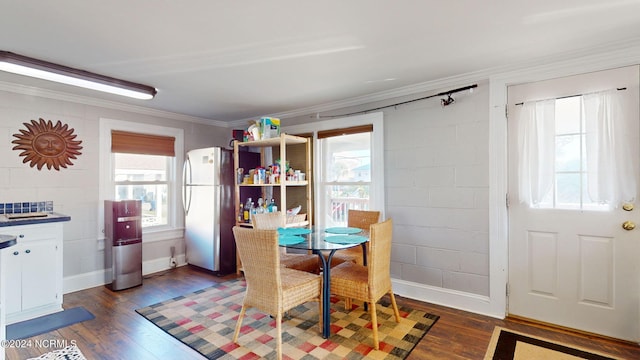 dining space featuring ornamental molding and dark hardwood / wood-style floors