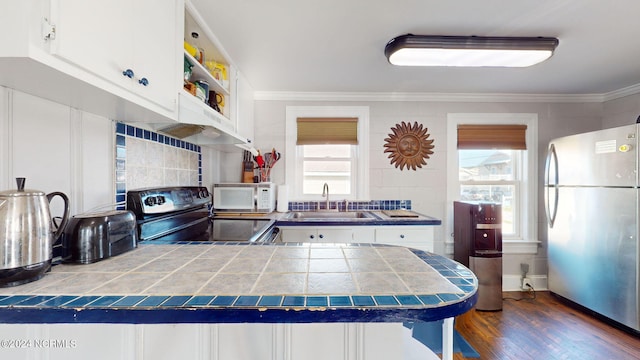 kitchen featuring sink, white cabinets, tile countertops, dark hardwood / wood-style flooring, and stainless steel fridge