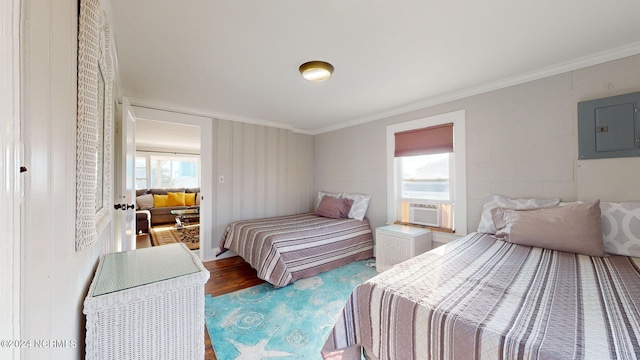 bedroom with ornamental molding, electric panel, and hardwood / wood-style flooring