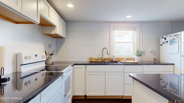 kitchen featuring backsplash, white cabinets, white appliances, and sink