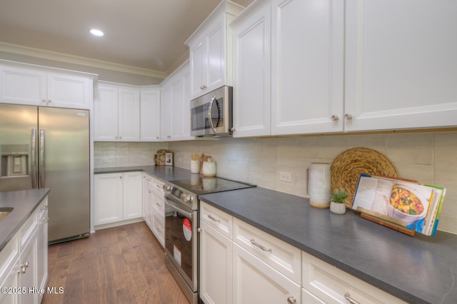 572 Hearthside Dr SE, Bolivia, NC 28422 - kitchen with stainless steel appliances, dark wood-type flooring, dark countertops, white cabinetry, and crown molding