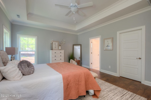 572 Hearthside Dr SE, Bolivia, NC 28422 - bedroom with a tray ceiling, dark wood-style flooring, ornamental molding, baseboards, and a ceiling fan