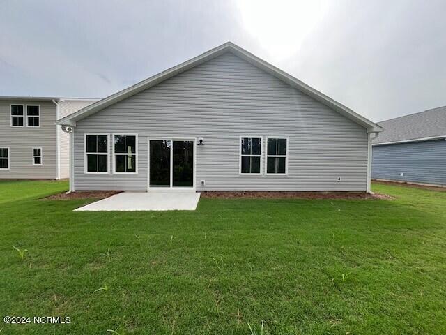 back of house with a lawn and a patio