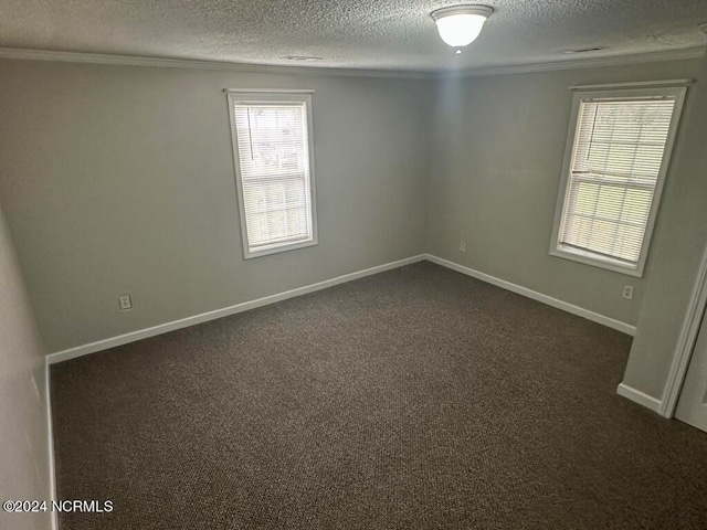 unfurnished room with a textured ceiling and dark colored carpet