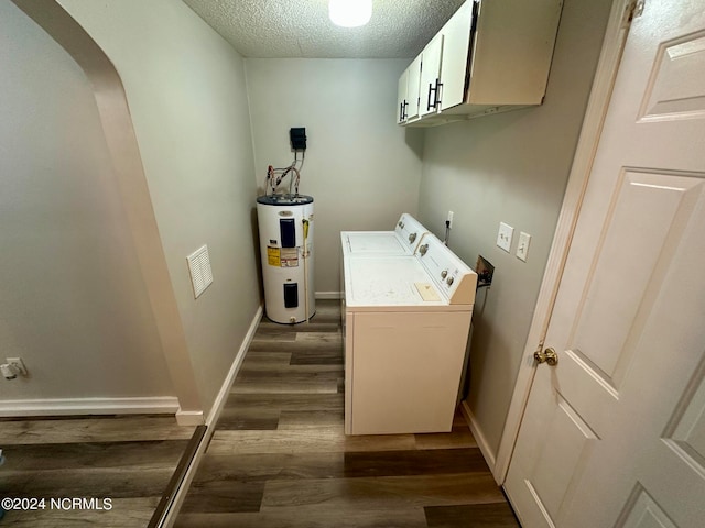 clothes washing area featuring cabinets, a textured ceiling, electric water heater, dark wood-type flooring, and washing machine and clothes dryer