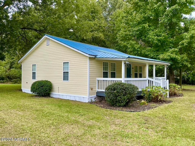 view of home's exterior featuring a porch and a yard