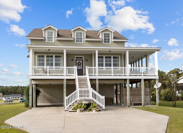 raised beach house with a carport, a front lawn, and covered porch