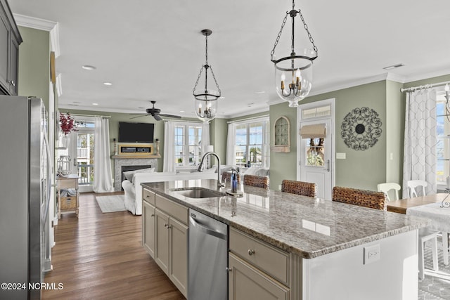 kitchen featuring stainless steel appliances, a sink, a fireplace, open floor plan, and ceiling fan with notable chandelier