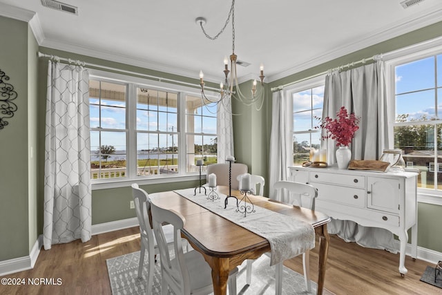 dining space with light wood-type flooring, visible vents, crown molding, and baseboards