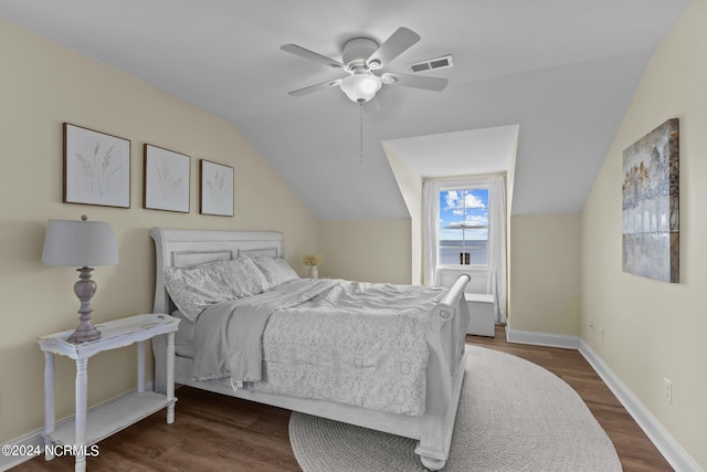 bedroom with ceiling fan, dark wood-type flooring, and vaulted ceiling