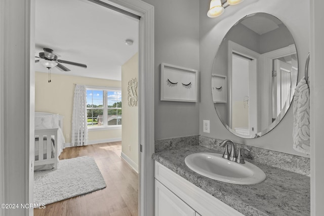bathroom with baseboards, a ceiling fan, wood finished floors, and vanity