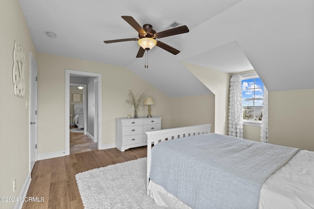 bedroom with ceiling fan, lofted ceiling, wood finished floors, and baseboards