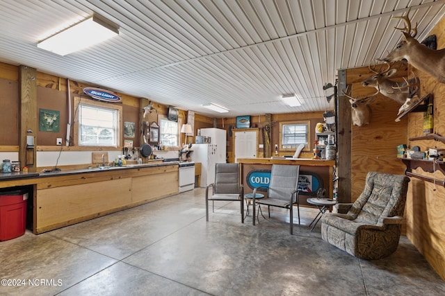 kitchen with white gas range oven and concrete flooring