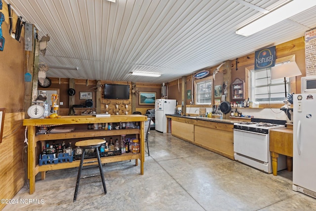 kitchen featuring wooden walls and white appliances