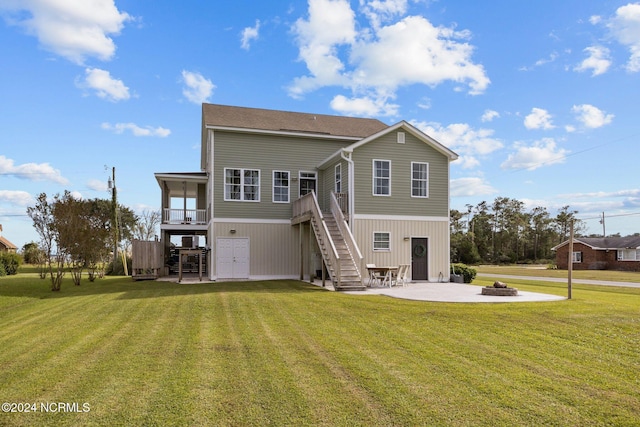 rear view of property featuring a deck, a fire pit, a yard, a patio, and stairs