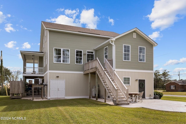 rear view of property with a patio and a lawn