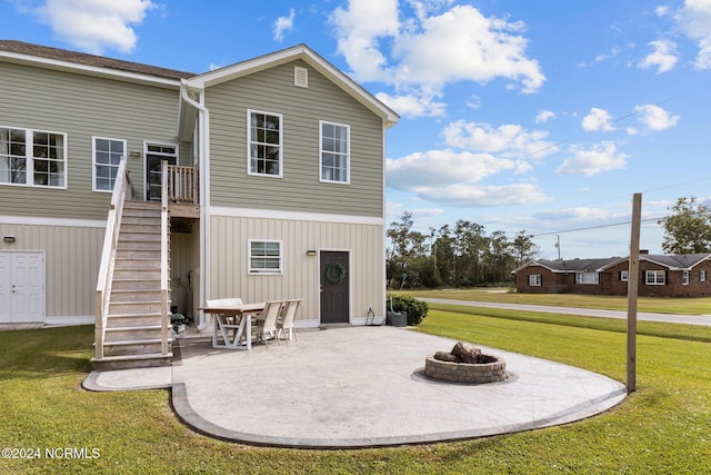 back of property with stairway, a yard, a patio, and an outdoor fire pit
