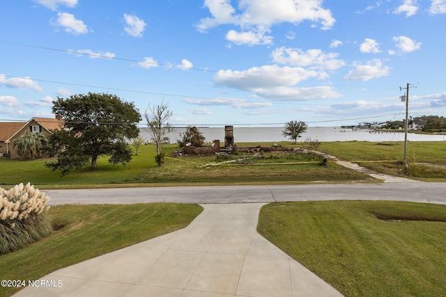 view of property's community with a yard and a water view