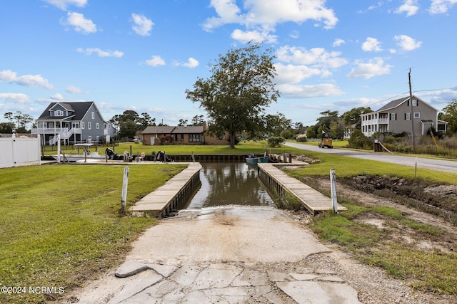 dock area with a water view and a lawn