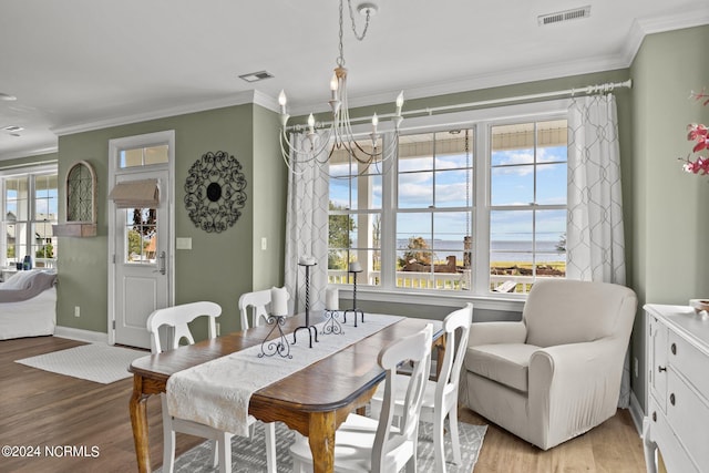 dining room with plenty of natural light, crown molding, and light wood-type flooring