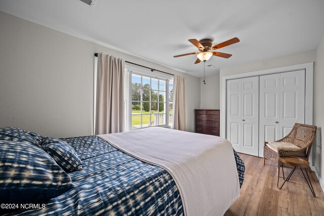 bedroom with multiple windows, dark hardwood / wood-style flooring, a closet, and ceiling fan