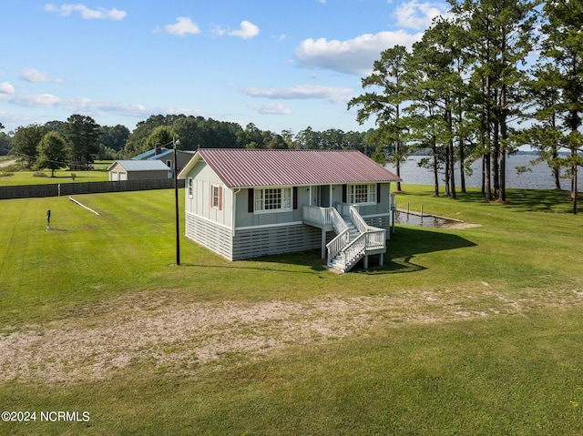 view of front facade with a water view, covered porch, and a front lawn