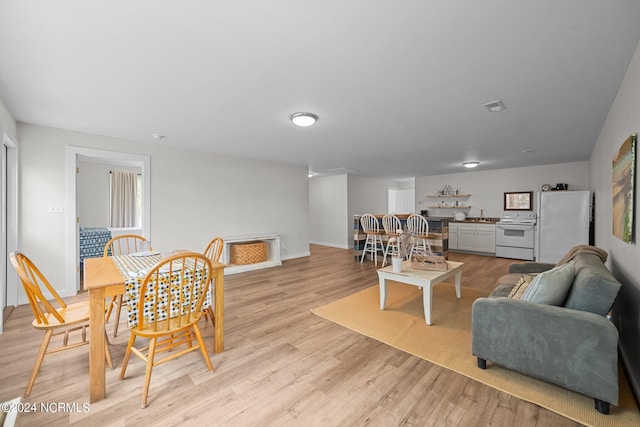 living room featuring sink and light hardwood / wood-style flooring