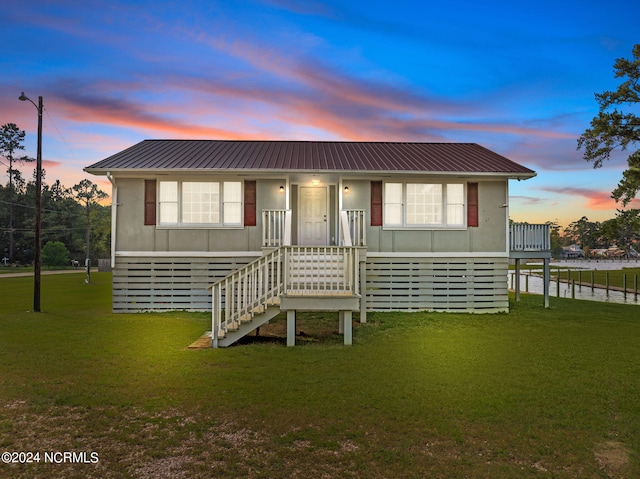 back house at dusk with a lawn