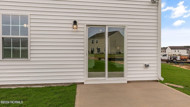 property entrance with a lawn